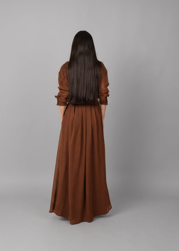 فستان بني بلمسة تراثية من صوف البشت والتياب الرجالية