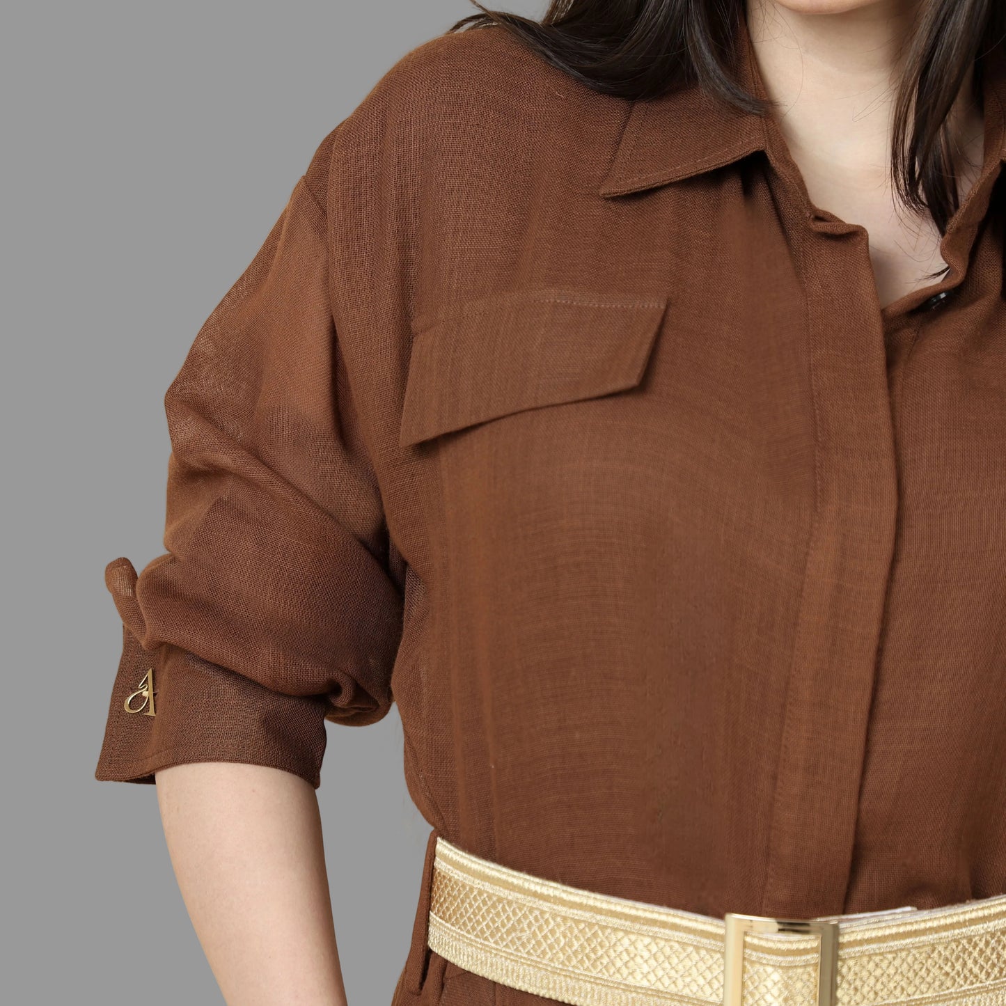 فستان بني بلمسة تراثية من صوف البشت والتياب الرجالية