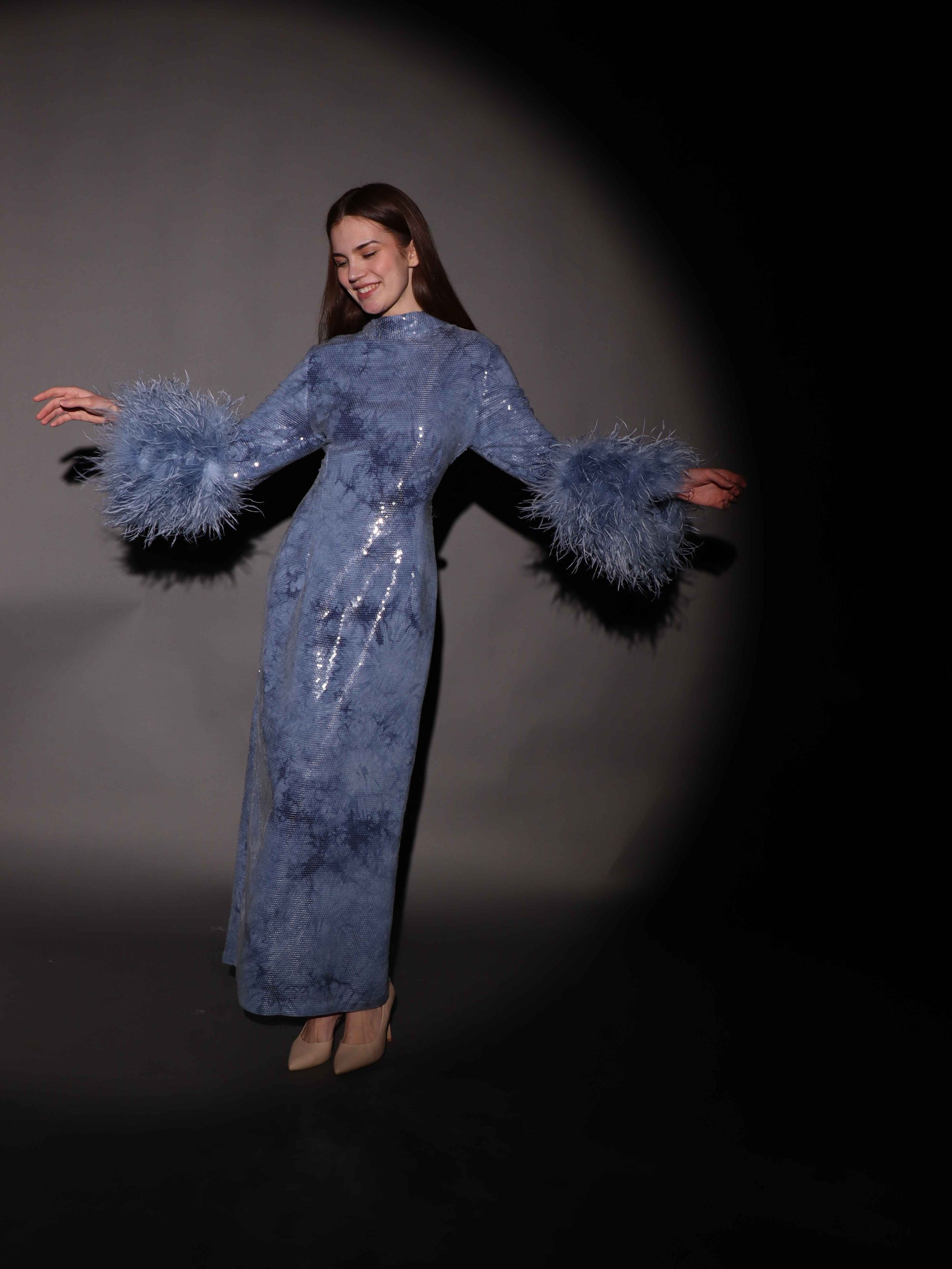 فستان أزرق لامع بأكمام ريش فاخرة