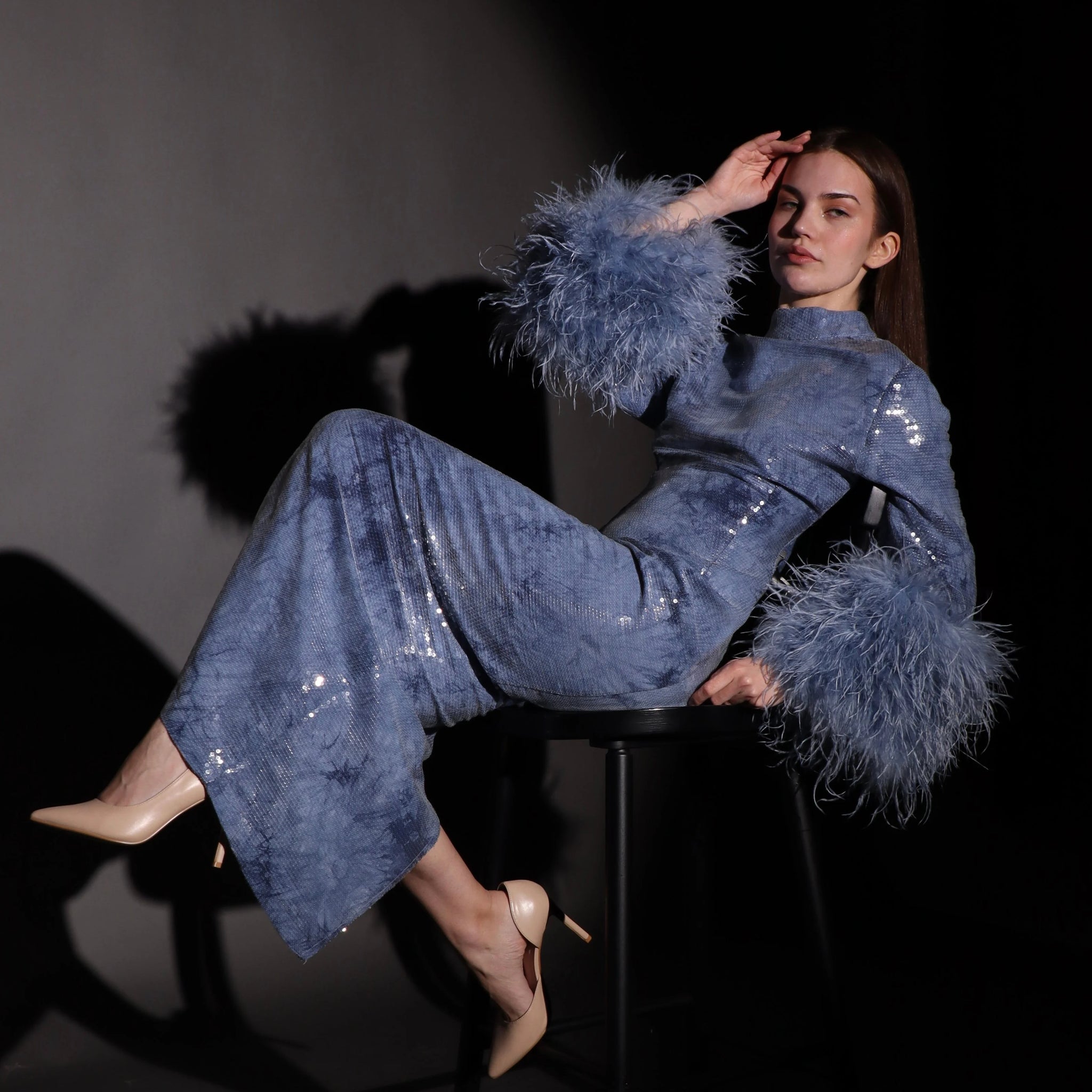 فستان أزرق لامع بأكمام ريش فاخرة